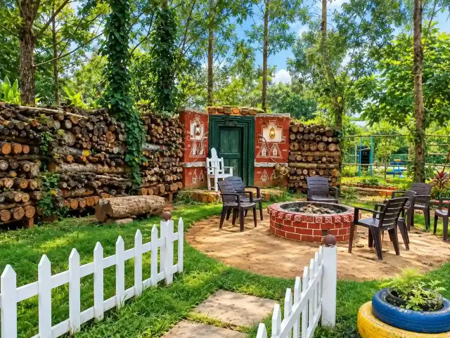 Campfire circle with a log wall and painted village door