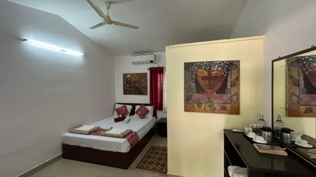 Deluxe AC Cottage — the bed, wall paintings and tea tray