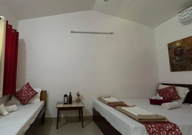 Deluxe AC Cottage — a single bed and the double bed with a side table between