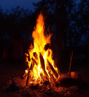 Log campfire blazing at night in the Ember Circle