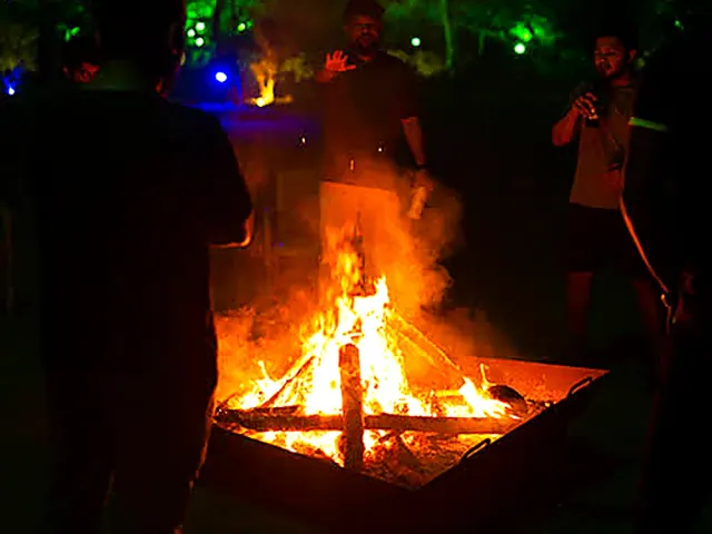 Guests gathered around the Ember Circle campfire at night