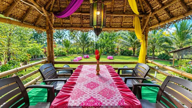Bamboo pergola dining with a pink-laid table