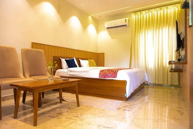 Premium AC Cottage — the room, with the bed, sitting corner and TV