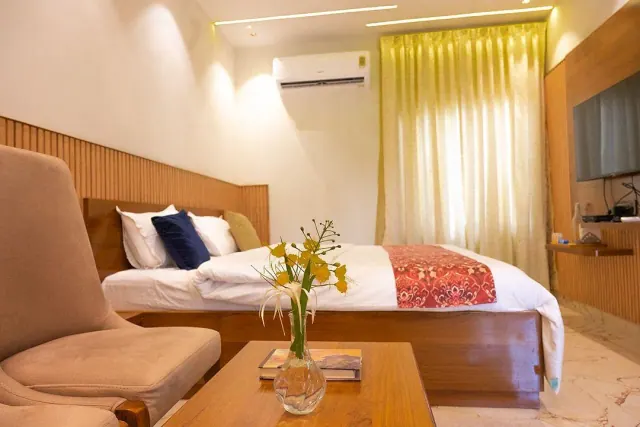 Premium AC Cottage — the bed seen from the armchairs