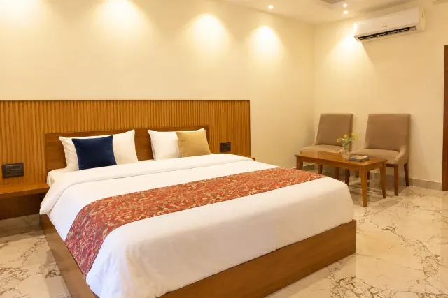 AC cottage bedroom with a king-size bed and a sitting corner